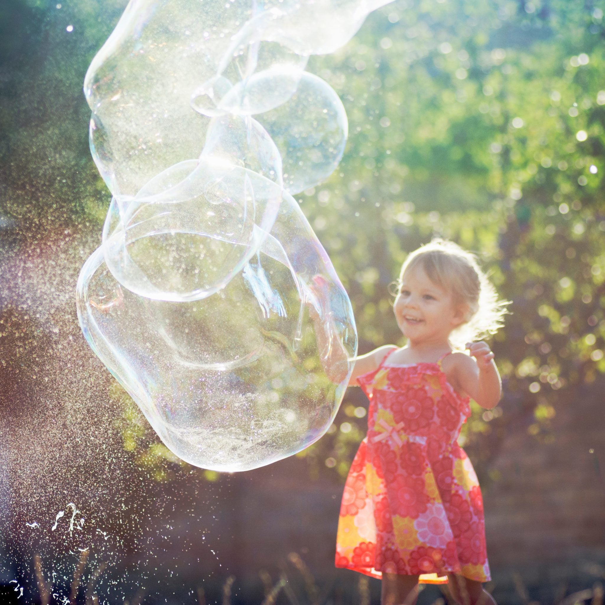 Little blonde girl creating bubbles